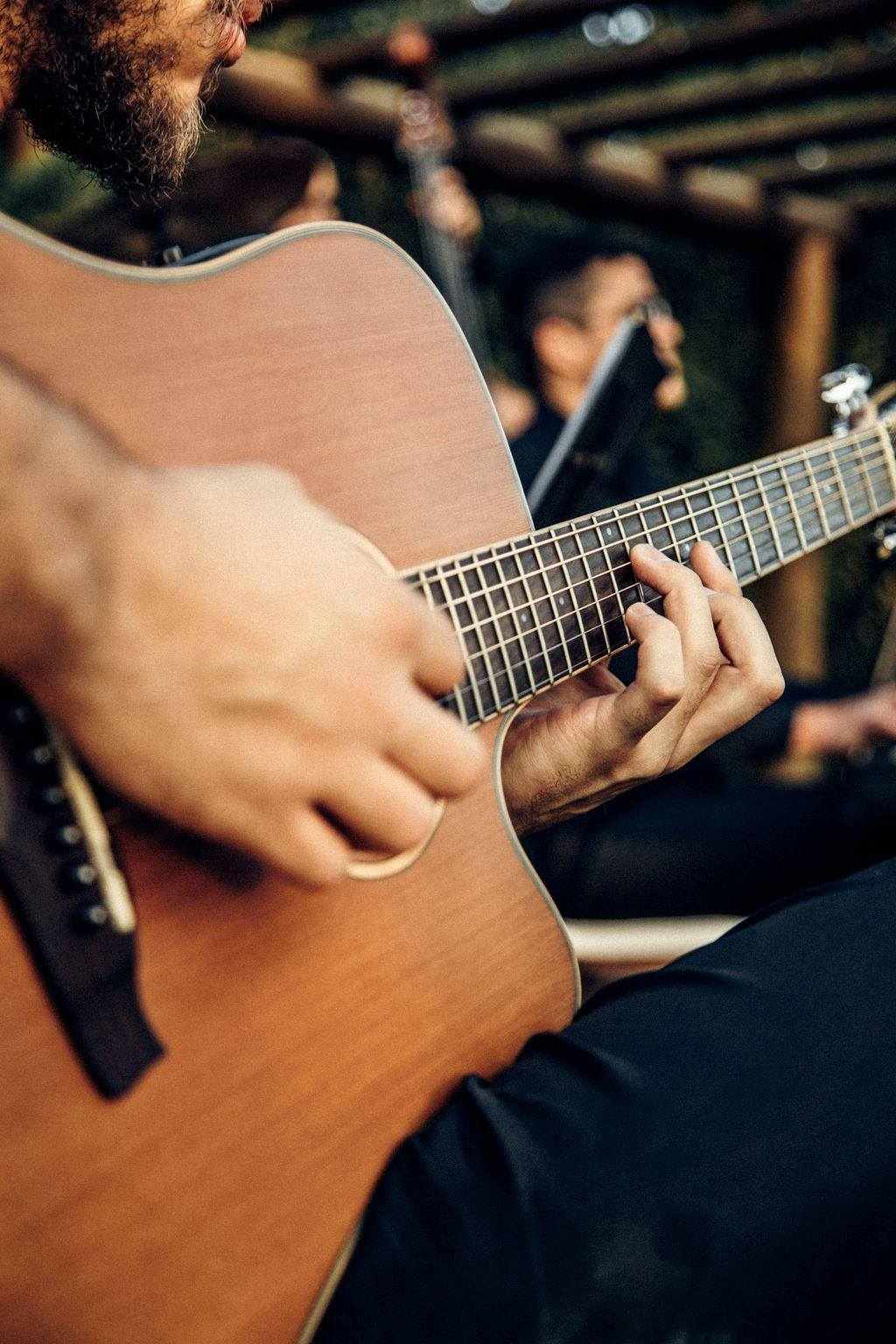 Đôi bàn tay đang chơi guitar acoustic